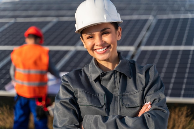 Schöne, elegante Ingenieurin in Uniform, die in der Nähe des Solarpanels steht