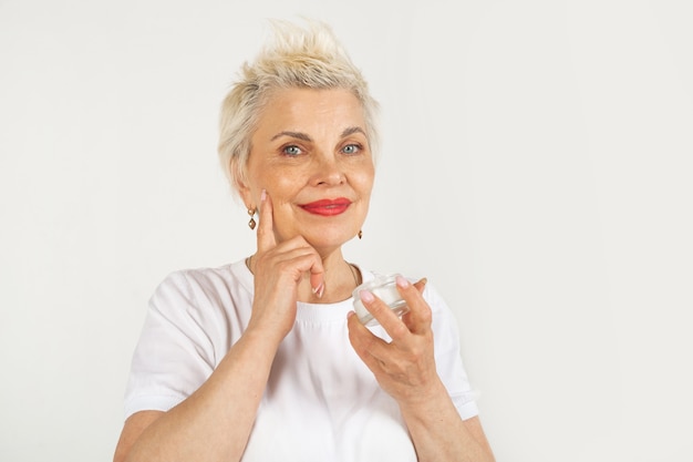 schöne erwachsene Frau im Alter mit Anti-Aging-Creme