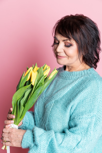 Schöne erwachsene Frau mit gelben Tulpen