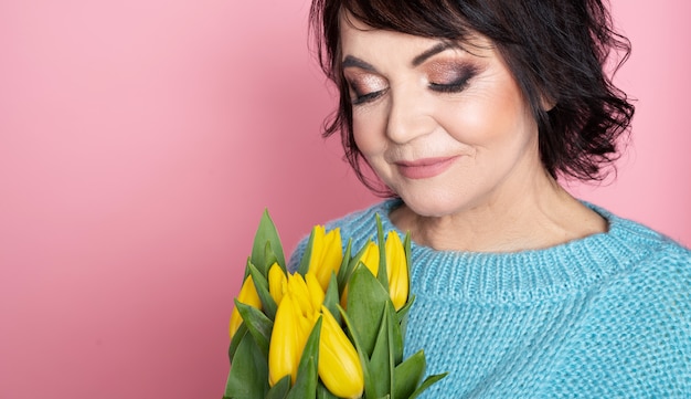 Schöne erwachsene Frau mit gelben Tulpen