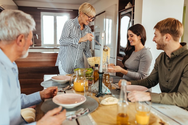 Schöne Familie, die das Wochenende zu Hause genießt und zusammen zu Mittag isst?