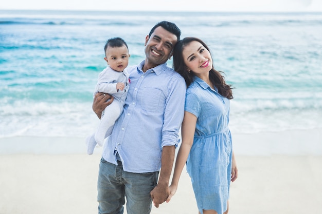 Schöne Familie, die im Urlaub am Strand lächelt