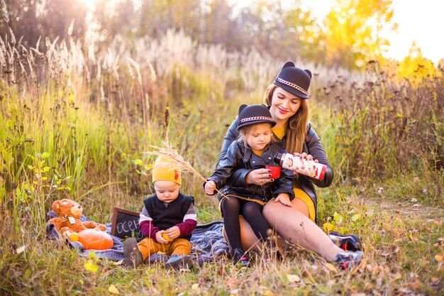 Schöne Familie mit einem Golden Retriever Hund auf einem Spaziergang in der sonnigen Natur des Herbstes