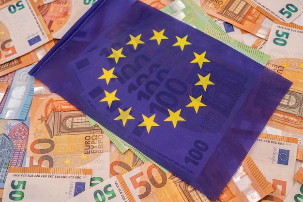 Schöne farbige neue Euro-Scheine, auf denen die blaue Euro-Flagge liegt. Das Konzept der Europäischen Union