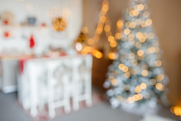 Schöne feiertagsgeschmückte Küche mit Weihnachtsbaum und hellen Lichtern unscharf geschossen