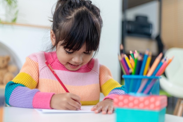 Schöne Ferien. Asiatische kleine Kinder machen Karten, Geschenke und Dekorationen für den Urlaub. Nette Kinder beschäftigen sich mit Kreativität.