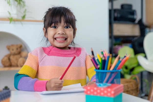 Schöne Ferien. Asiatische kleine Kinder machen Karten, Geschenke und Dekorationen für den Urlaub. Nette Kinder beschäftigen sich mit Kreativität.