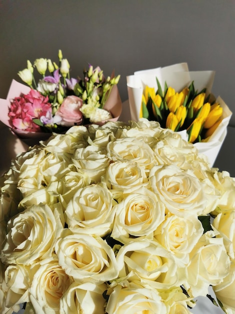 Schöne florale Geschenksträuße aus Rosen, gelben Tulpen und einem kombinierten Blumenstrauß aus Eustoma-Nelken-Ranunculus-Alstroemeria-Rosen aus nächster Nähe