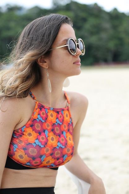 Schöne Frau am Strand mit schwarzer Sonnenbrille mit schönem Hintergrund