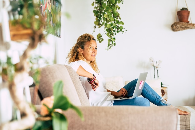 Foto schöne frau arbeitet und entspannt sich zu hause mit laptop-computer