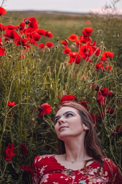 Schöne Frau auf dem Mohnblumengebiet