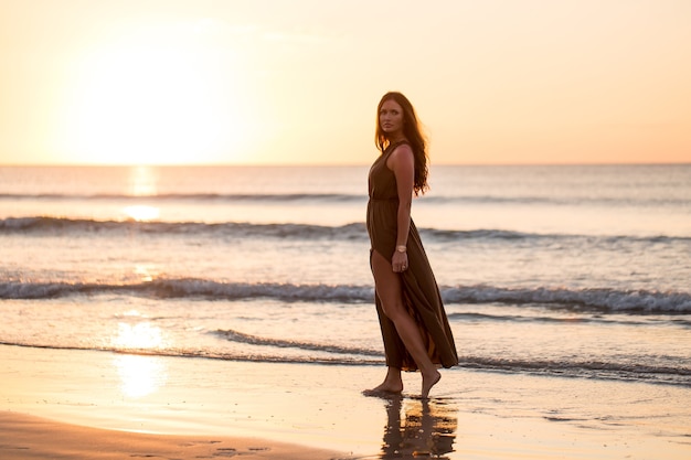 Schöne Frau auf Sonnenunterganghintergrund