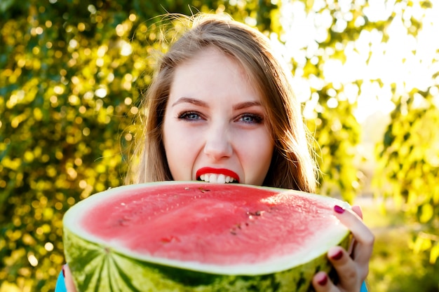 Schöne Frau beißt eine Wassermelone