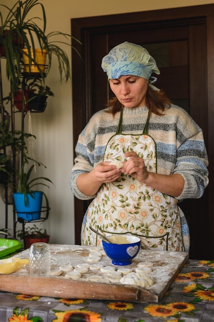 Schöne Frau bereitet Knödel in ihrer heimischen Küche zu Knödel mit Kartoffeln