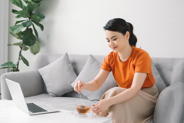 Schöne Frau bereitet morgens zu Hause eine Tasse Tee zu.