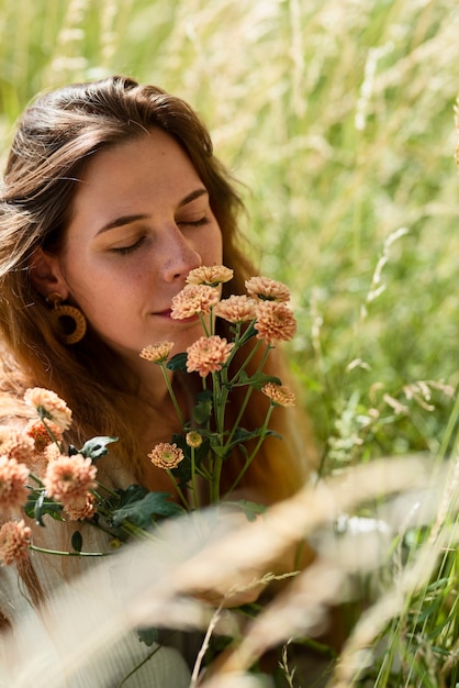 Foto schöne frau des hohen winkels, die mit blumen aufwirft