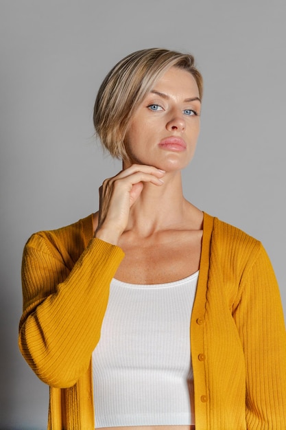 Schöne Frau des Porträts des vorbildlichen Aussehens Mädchen im gelben Pullover Studiophotographie