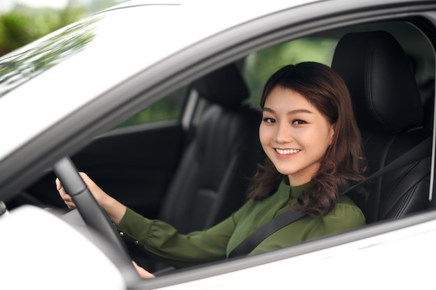 Schöne Frau, die am Steuer eines Autos sitzt