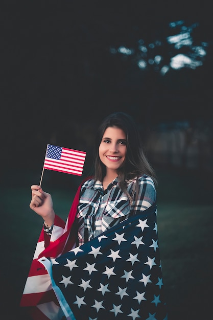 Schöne Frau, die amerikanische Flagge - Bild anhält