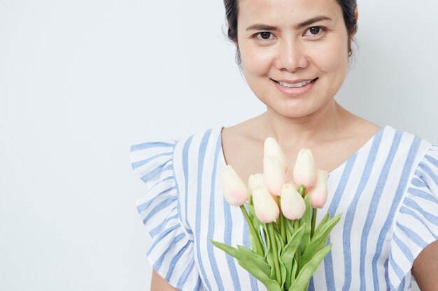 Schöne Frau, die Blumenstrauß der Tulpen anhält
