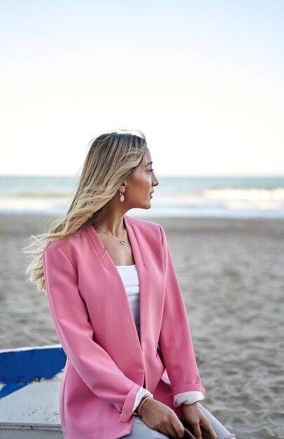 Foto schöne frau, die das meer an einem strand betrachtet