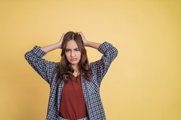 Schöne Frau, die den Kopf mit beiden Händen hält, wenn sie beim Stehen mit Exemplar schwindlig ist