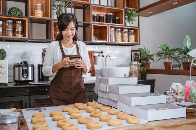 Schöne frau, die donuts in der küche vorbereitet