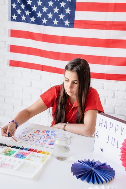 Schöne Frau, die eine Aquarellillustration für Unabhängigkeitstag der USA zeichnet