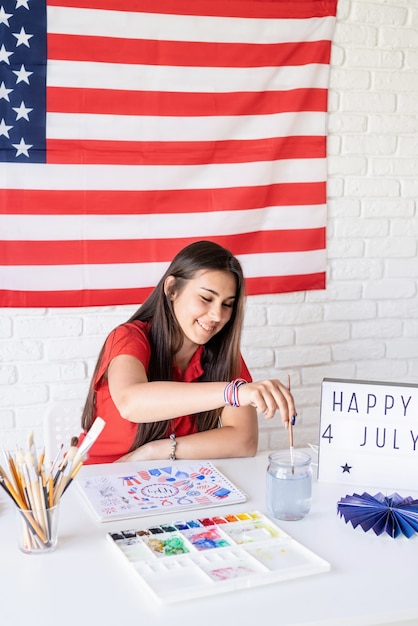 Schöne Frau, die eine Aquarellillustration für Unabhängigkeitstag der USA zeichnet