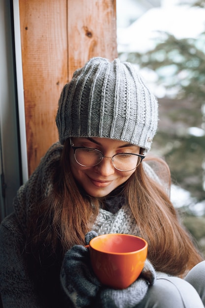 Schöne Frau, die eine Tasse Kaffee hält und trinkt