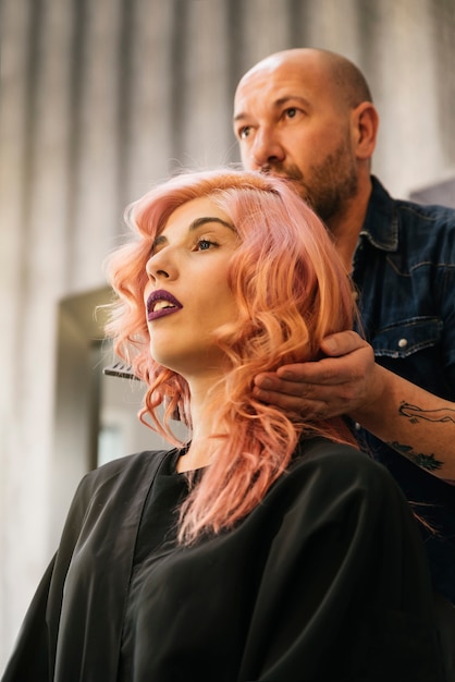 Schöne Frau, die Haarschnitt durch Friseur im Schönheitssalon erhält.