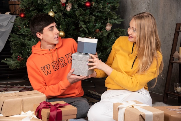 Schöne Frau, die ihren Freund anschaut und ihm Geschenke zu Hause gibt.