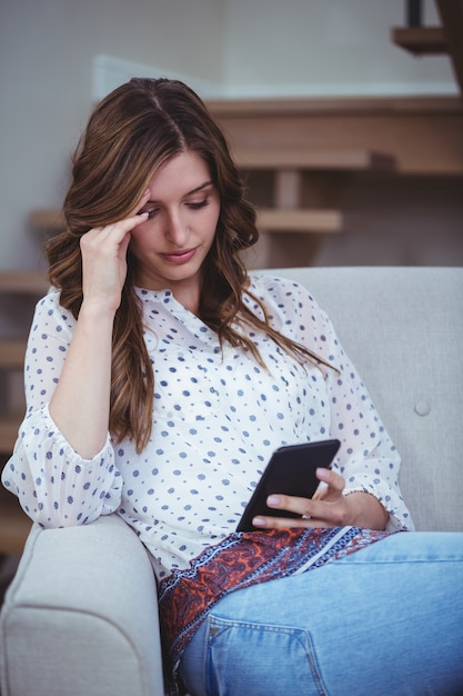 Schöne Frau, die ihren Handy betrachtet