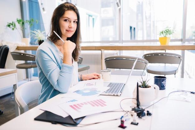 Schöne Frau, die im Büro arbeitet