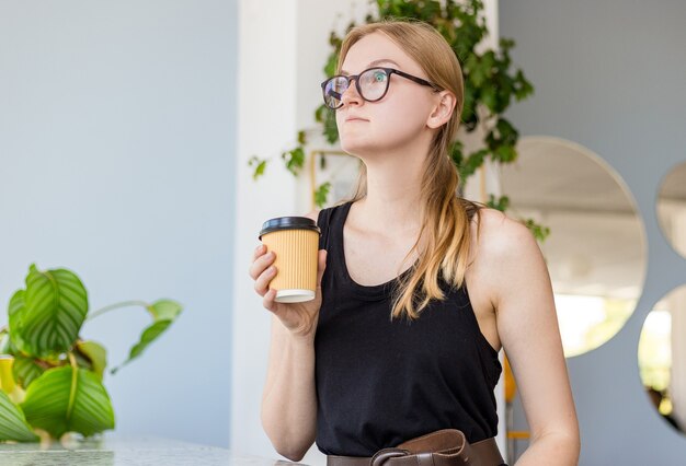 Schöne Frau, die im Café sitzt und Kaffee trinkt