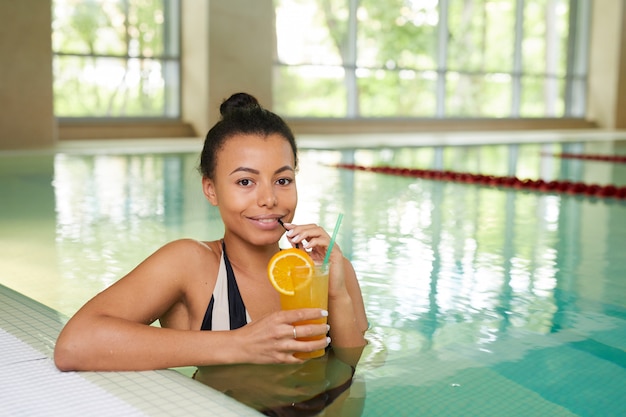 Schöne Frau, die im Schwimmbad aufwirft