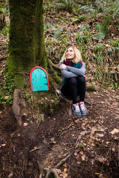 Schöne Frau, die im Wald sitzt