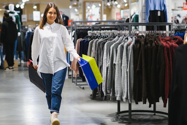 Schöne Frau, die Kleidung in einem Geschäft kauft