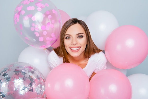 Schöne Frau, die mit Luftballons aufwirft