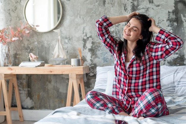 Schöne Frau, die Morgen im Pyjama genießt