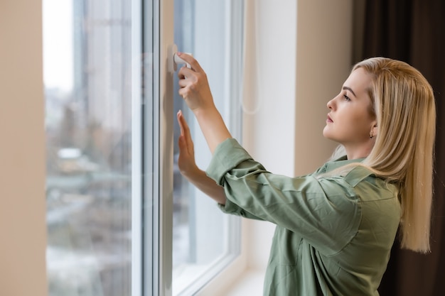 Schöne Frau, die morgens das Fenster öffnet