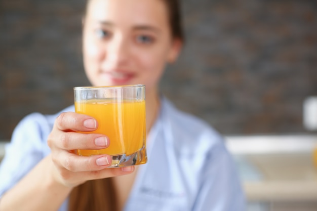 Foto schöne frau, die orangensaftglas hält