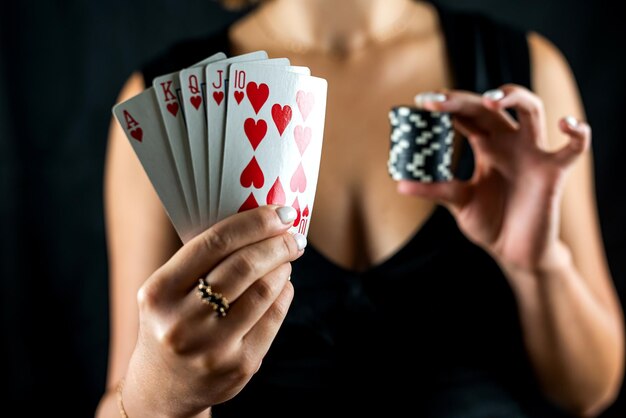 Schöne Frau, die Poker spielt und Casino-Chips und Dollar hält und das Gewinnen genießt