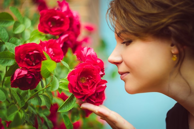 Foto schöne frau, die rote rosen riecht