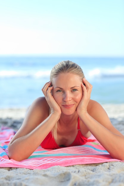 Schöne Frau, die sich auf dem Strand hinlegt