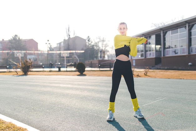 Schöne Frau, die sich vor dem Training ausdehnt