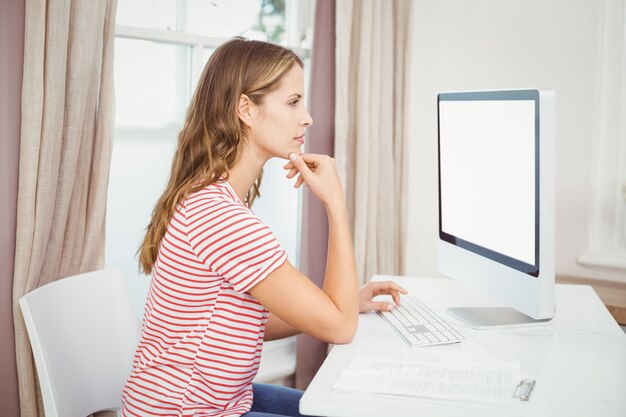 Schöne Frau, die zu Hause Computer verwendet