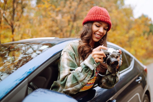 Schöne Frau fotografiert aus dem Autofenster mit der Kamera Rest-Entspannungs-Lifestyle-Konzept