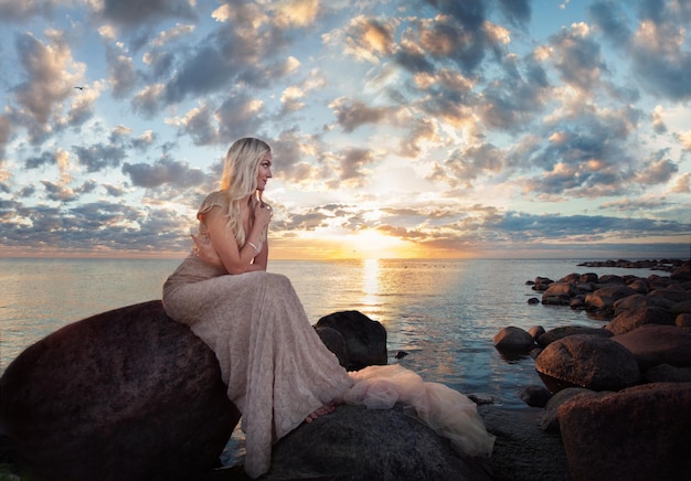 Schöne Frau gegen Meer und Himmel im Freien Romantischer Sonnenuntergang