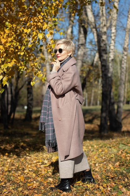 Schöne Frau geht im Herbst im Park spazieren